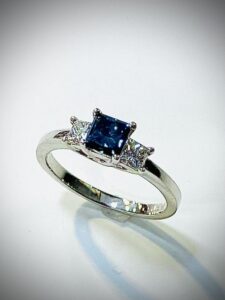 Weissgold mit drei Princess Diamanten, in der Mitte blau